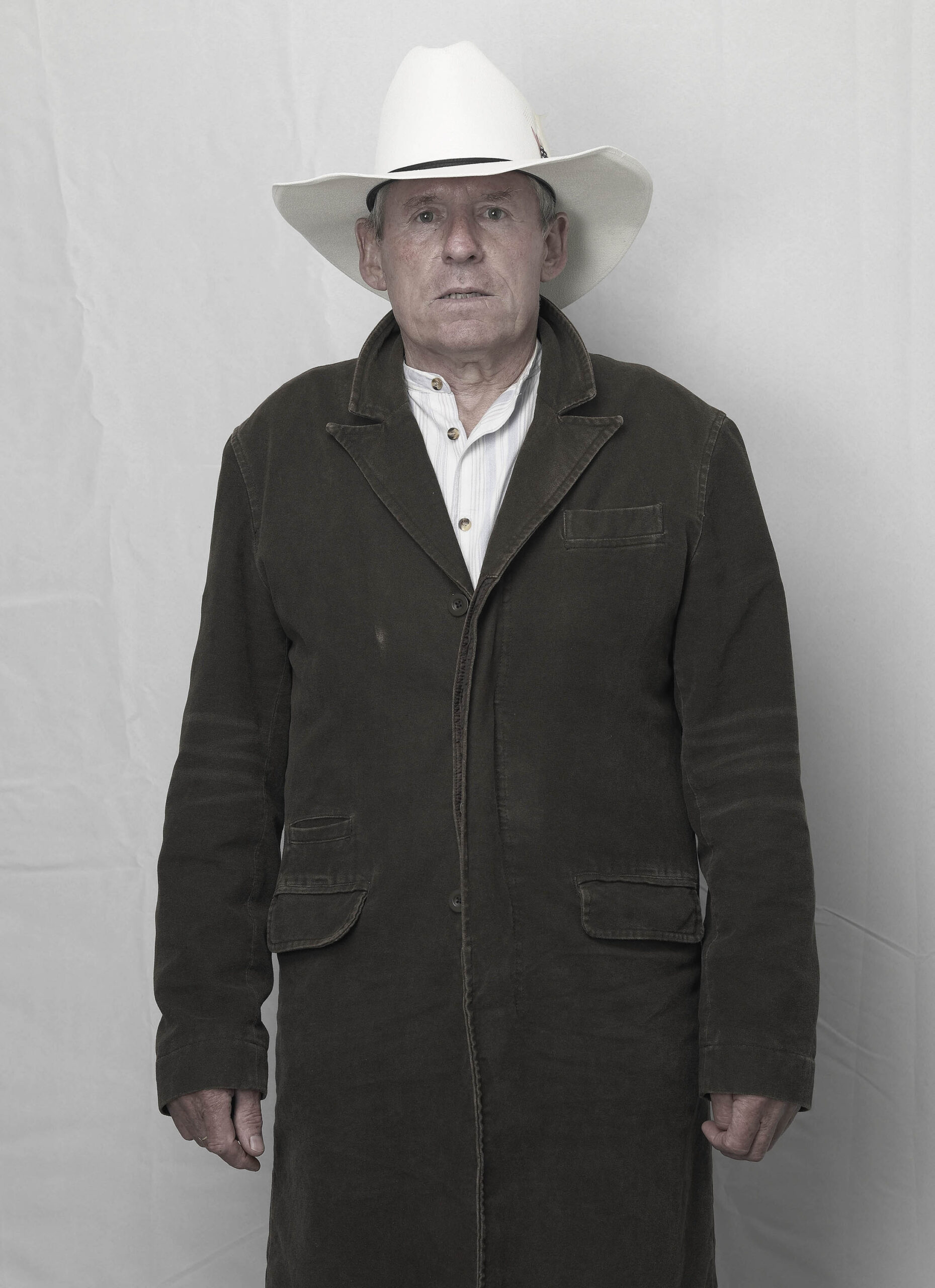 man in western clothes and cowboy hat against white background