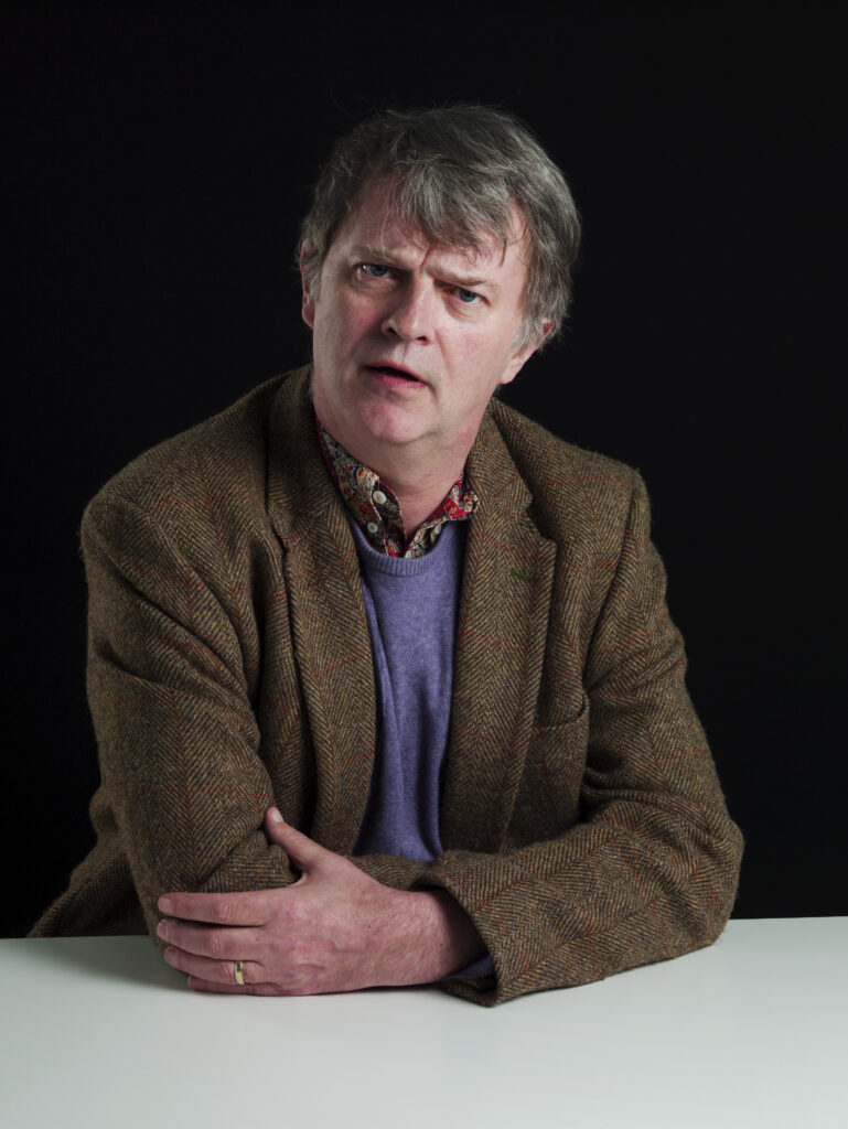 Paul Merton looking to camera.