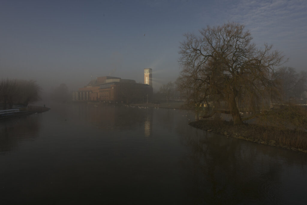 RSC theatre in early morning mist with sunlight reflecting from building looking like a lighthouse