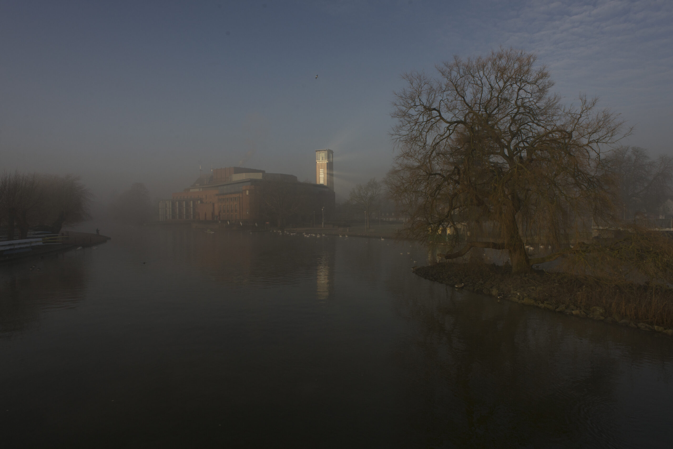 RSC theatre in early morning mist with sunlight reflecting from building looking like a lighthouse